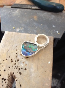 Boulder opal being fitted with a bezel.